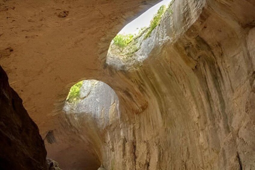A canyon with two rock formations and a sandy ground. 3