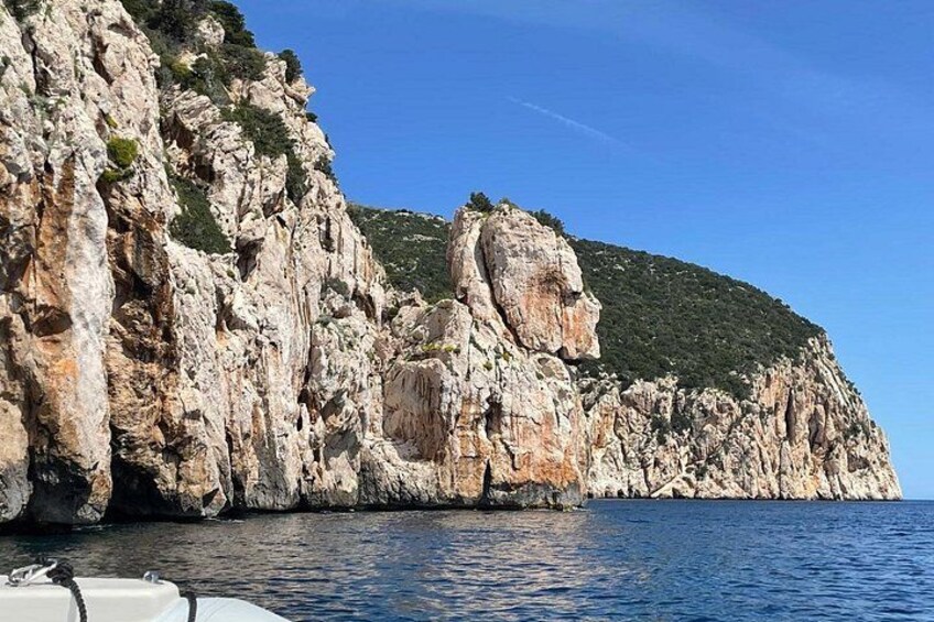 A rocky coastline with cliffs and a boat in the foreground. 2