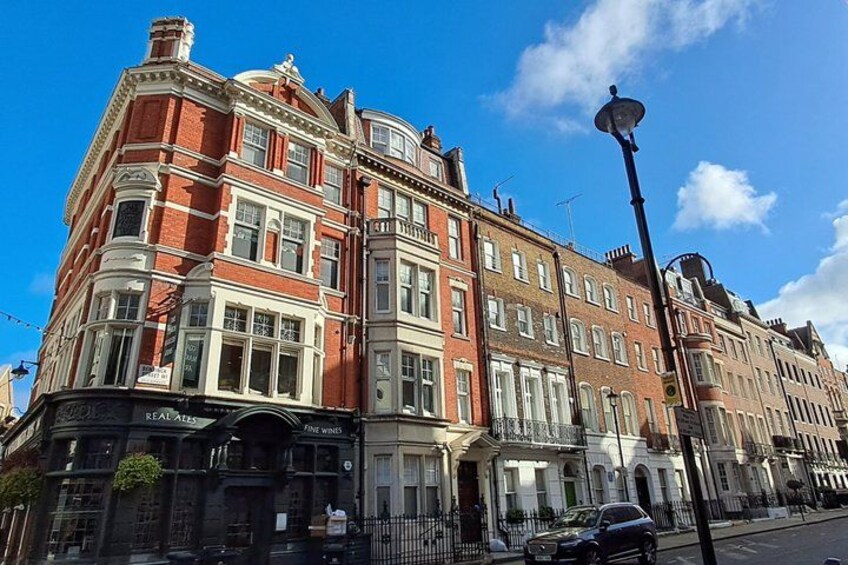 A red brick building with white trim, a black awning, and a street lamp. 5