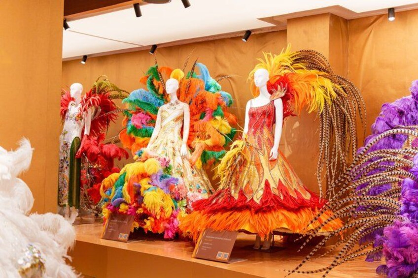 Mannequins in colorful, feathered dresses. 1