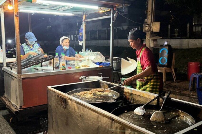 A street food vendor cooking at night. 2