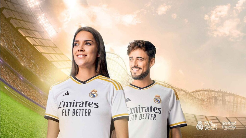 Two people wearing white sports jerseys with 'Emirates Fly Better' and 'Real Madrid' logos. 2