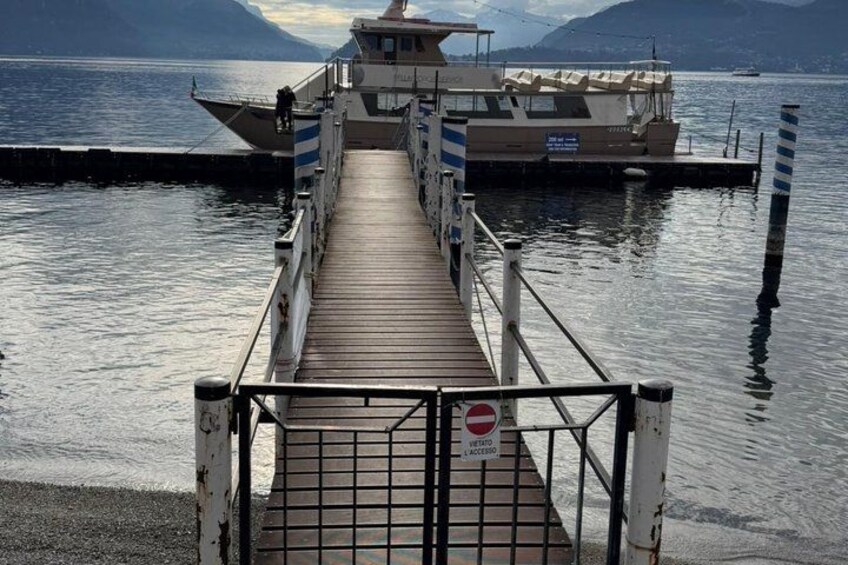 A pier leading to a boat, with a 'No Entry' sign and mountains in the background. 4