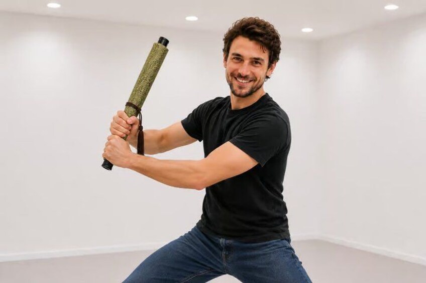 A person holding a cylindrical object, wearing a black t-shirt and jeans, in a room with white walls and ceiling lights. 3