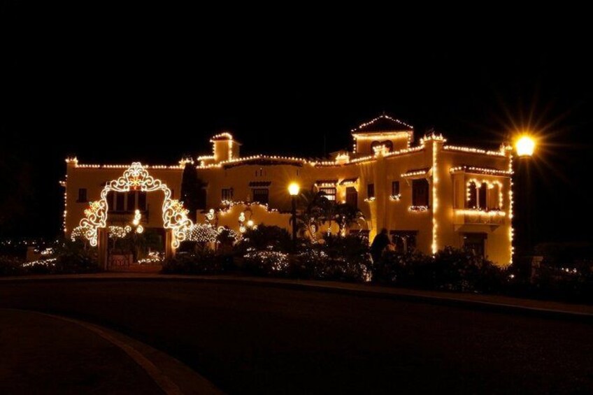 A building illuminated with lights, surrounded by greenery. 1
