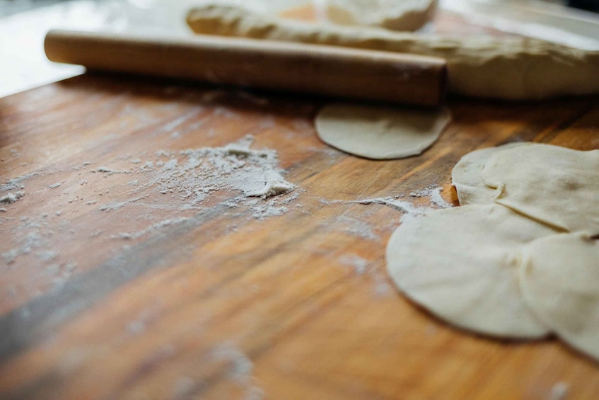 A wooden surface with dough and a rolling pin. 5