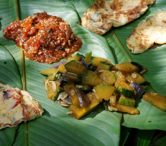 Small portions of cooked food on large leaves