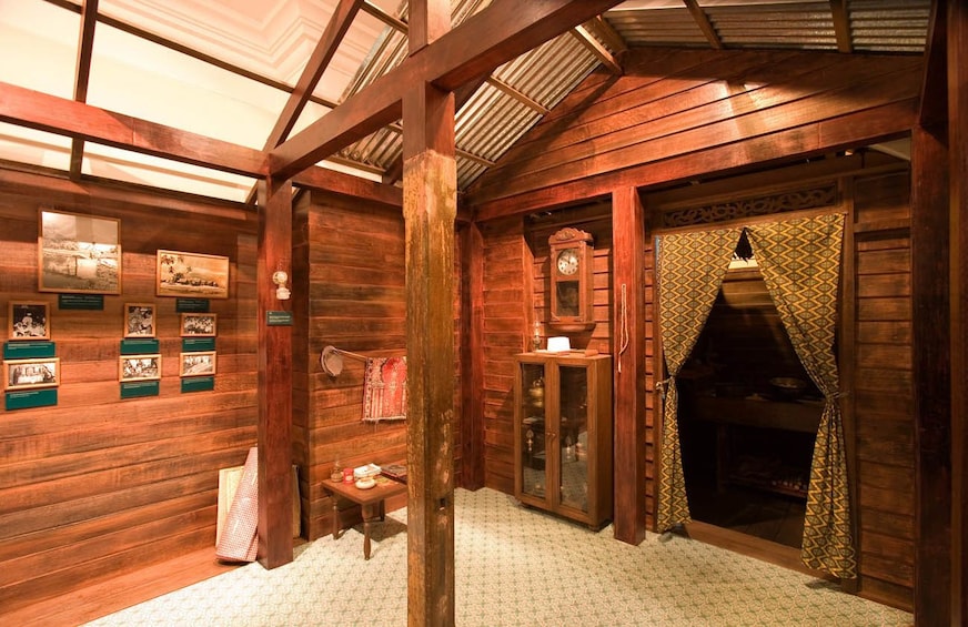 Ein rustikales Holzhaus-Interieur mit Kamin, Holzbalken und gerahmten Bildern an den Wänden. 5