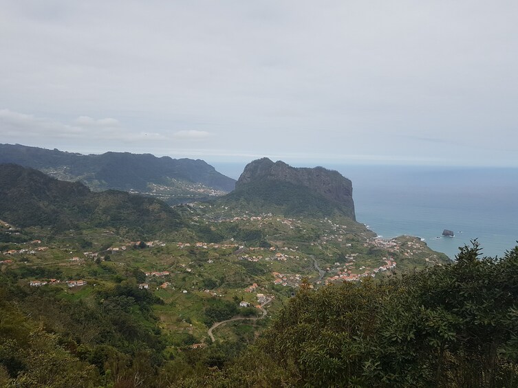 A coastal town nestled in a valley with rugged mountains in the background. 5