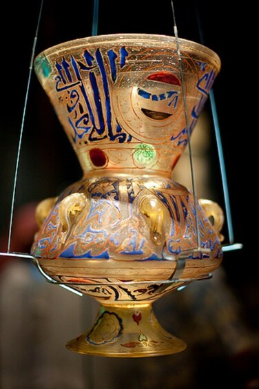 Een gouden beker met gedetailleerde blauwe en rode patronen en Arabische kalligrafie. 5