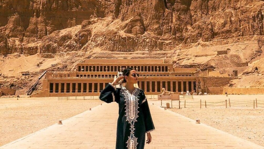 Woman poses in front of the Temple of Hatshepsut