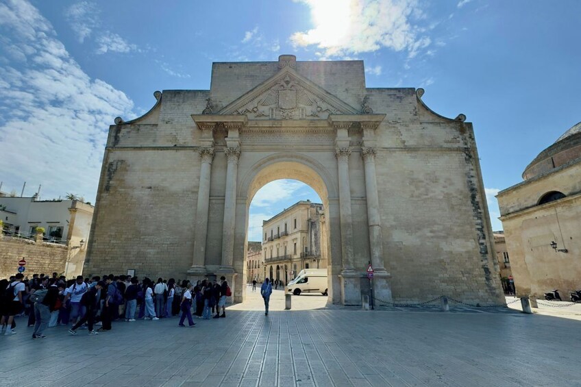 Un’antica arcata con turisti di fronte. 5