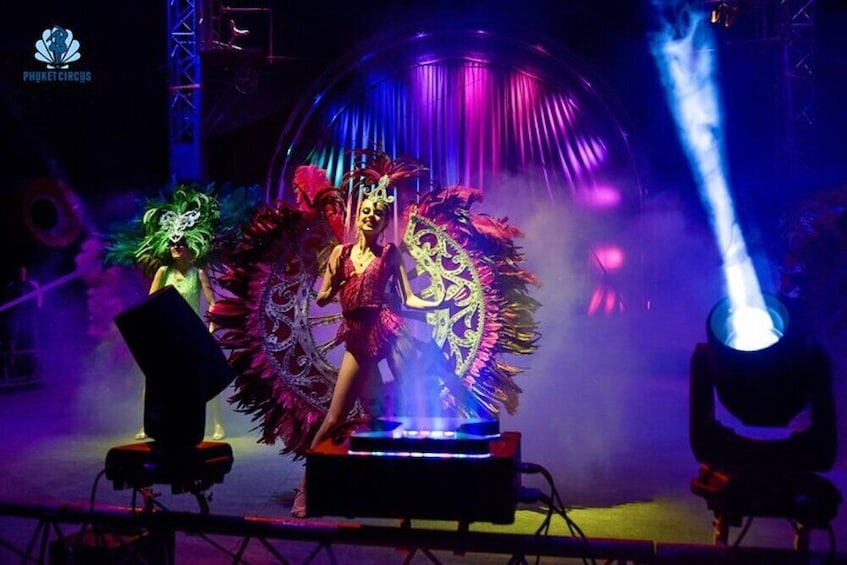 A stage with performers in elaborate costumes and a large decorative backdrop. 5