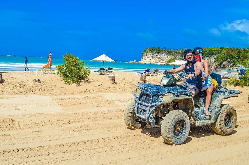 Couple ride quad bike along beach in the Dominican Republic