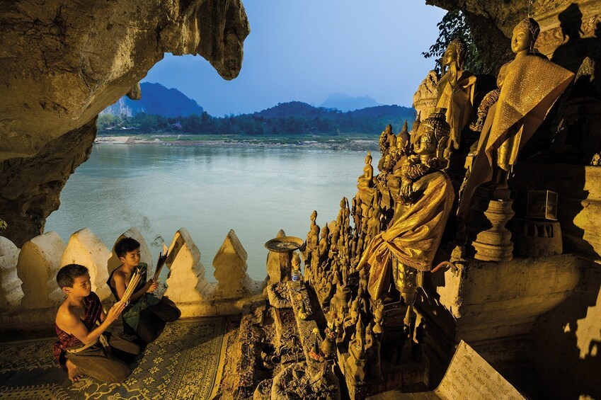 Two young boys worship in the Pak Ou Caves