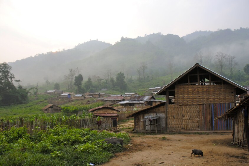 Homes and fields of Khmu village on a misty morning in Laos