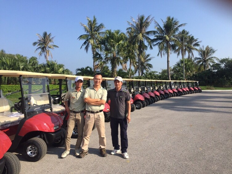 Men standing next to golf carts