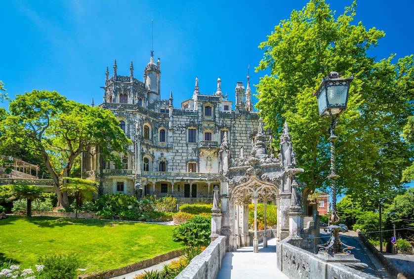 A grand historic building with ornate architecture, surrounded by lush greenery and a well-maintained garden. 2