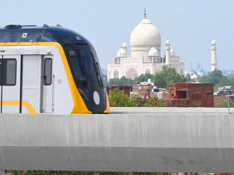 A train on a track with the Taj Mahal in the background. 1
