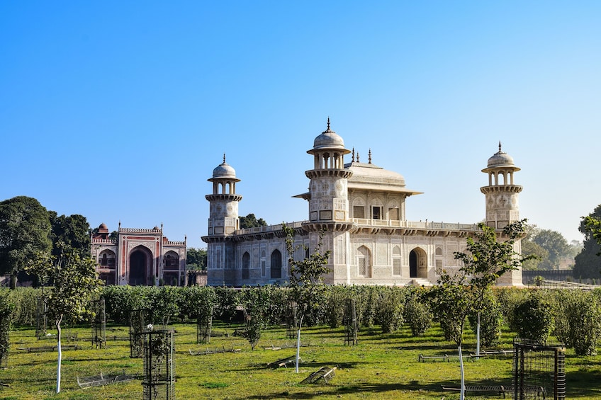 A large, ornate building with domes and minarets, surrounded by a well-maintained garden. 4