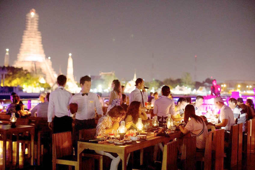 Guests enjoying dinner aboard the  Chaophraya dinner cruise