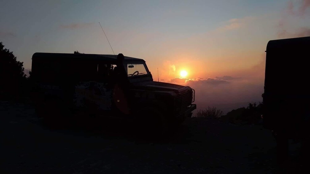 A vehicle parked at sunset with a sun in the background. 1