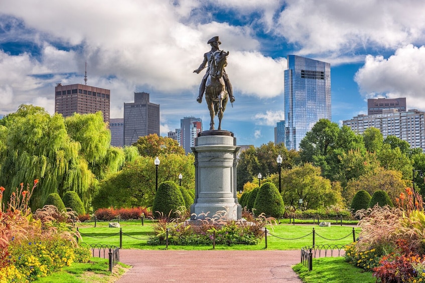Una statua in un parco con lo skyline della città sullo sfondo. 1
