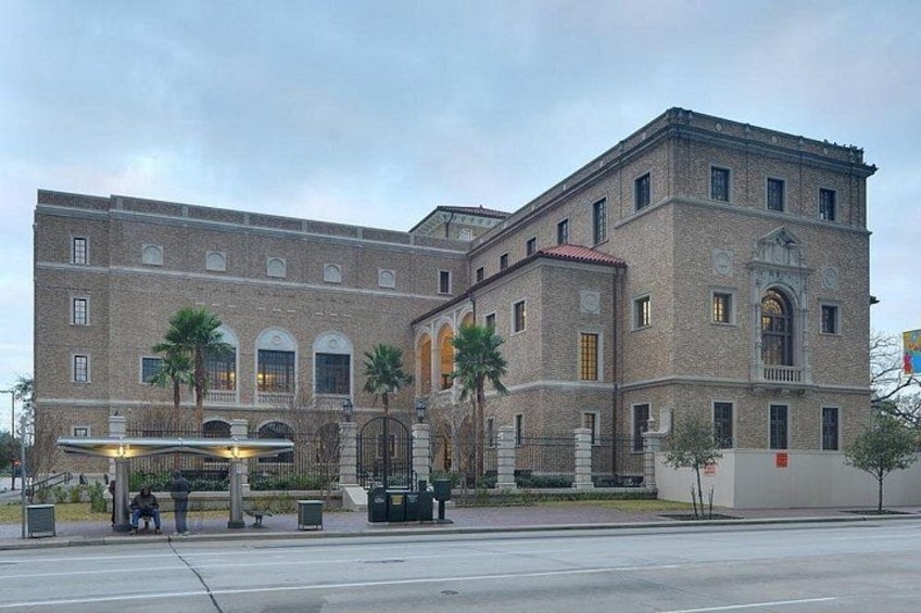 A large brick building with arched windows and a central entrance. 5