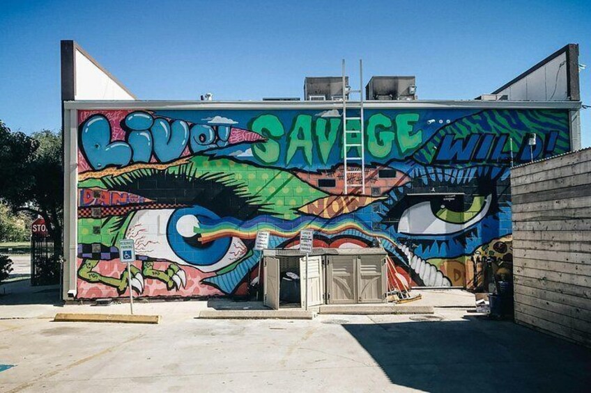 Un mural con un ojo grande y las palabras 'LIVOT SAVAGE WILD!' en un edificio. 5
