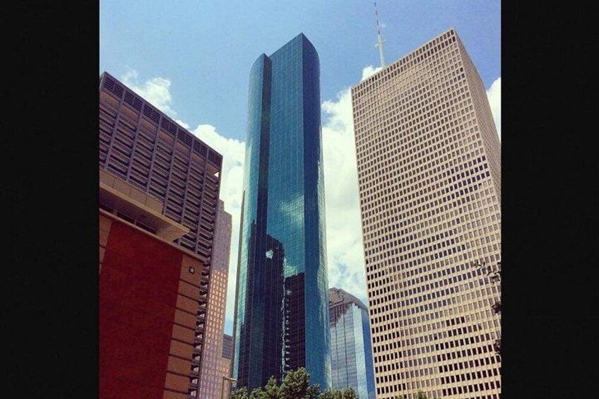 A cityscape with modern skyscrapers, one with a reflective glass facade and another with a grid-like pattern. 4