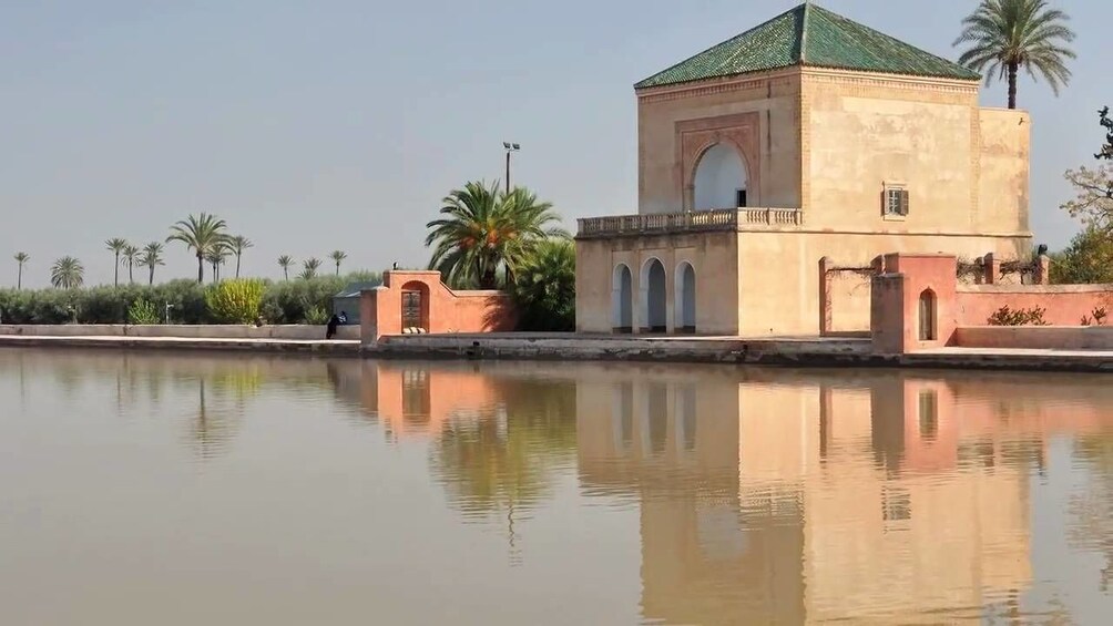A traditional building with a green roof and arched windows, reflecting in a calm body of water. 3