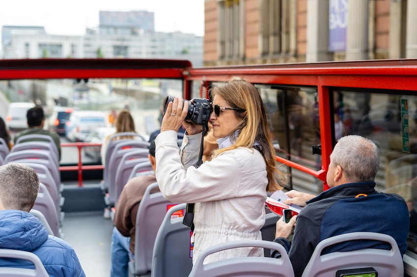 Una mujer tomando una foto con una cámara en un autobús. 4