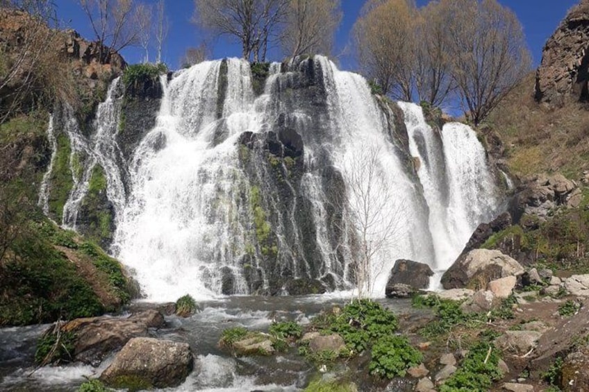 Una cascada en varios niveles rodeada de terreno rocoso y vegetación escasa. 2