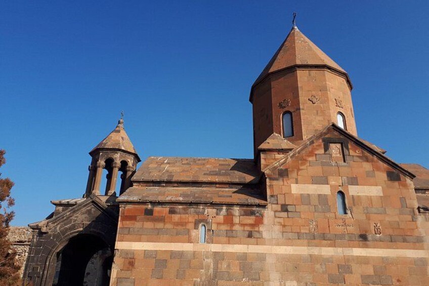 A historical church with a prominent bell tower and a smaller adjacent structure. 4