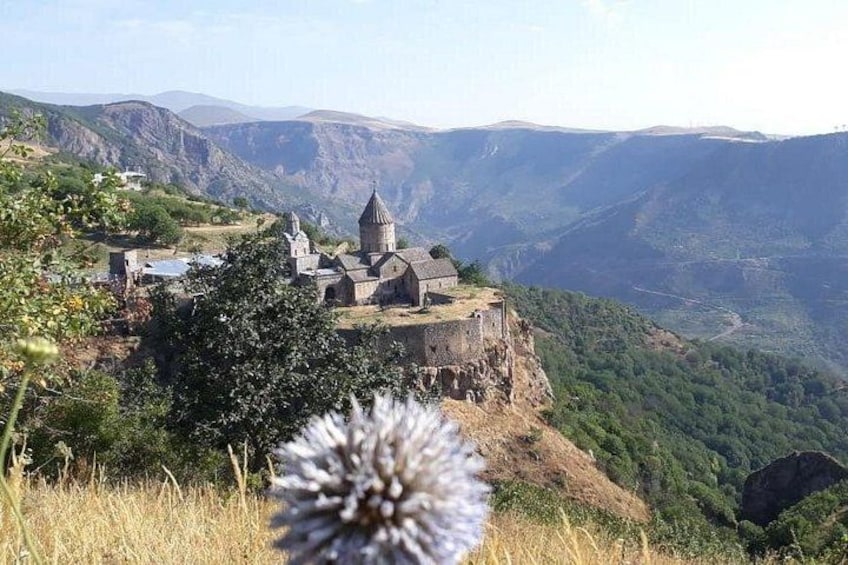 A historic church on a hilltop with a mountainous backdrop. 1