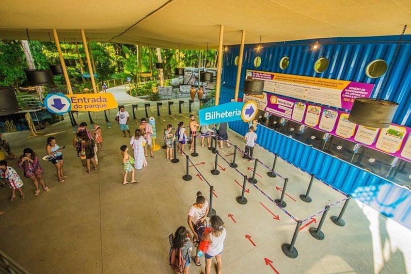 A queue area with people waiting, a sign for 'Entrada do parque', and a 'Bilheteria' booth. 2