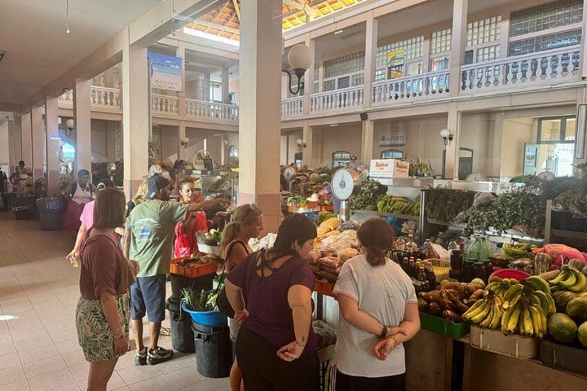 Een markt vol mensen die winkelen en verkopers die fruit en groenten verkopen. 1
