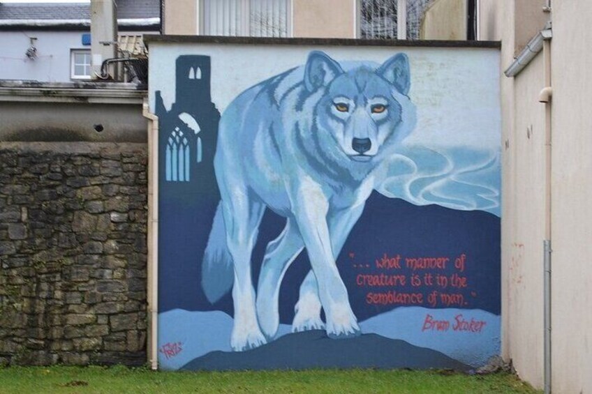 A mural of a wolf on a wall with a quote by Brian Sloane. 2