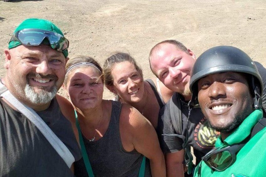 A group of people outdoors, some wearing helmets and casual clothing. 2
