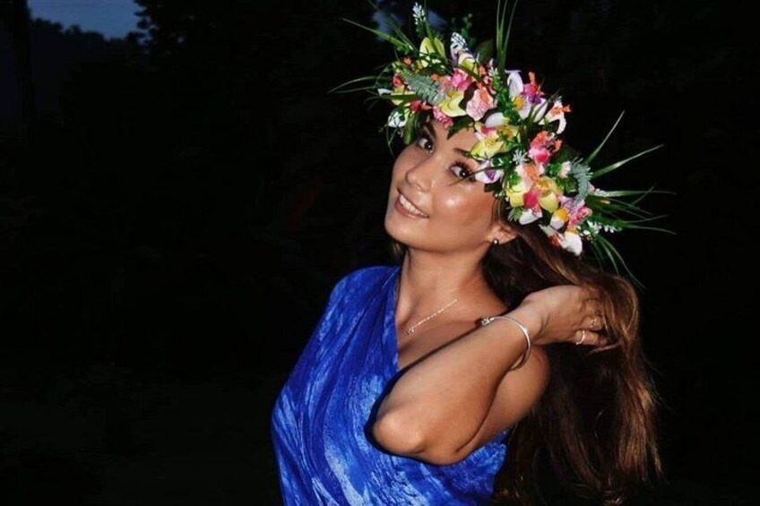 A person wearing a blue dress and a floral headpiece. 3