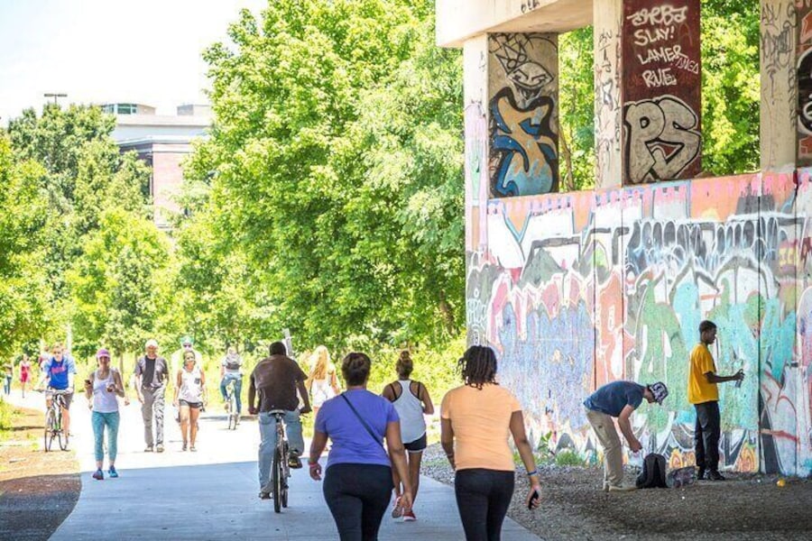 People walking and biking along the Atlanta BeltLine with public art installations.