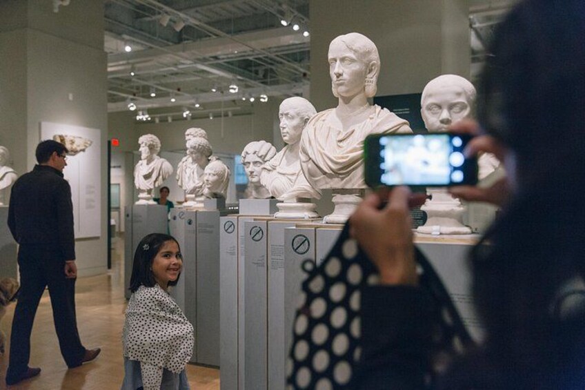 A museum interior with classical sculptures on display. 4