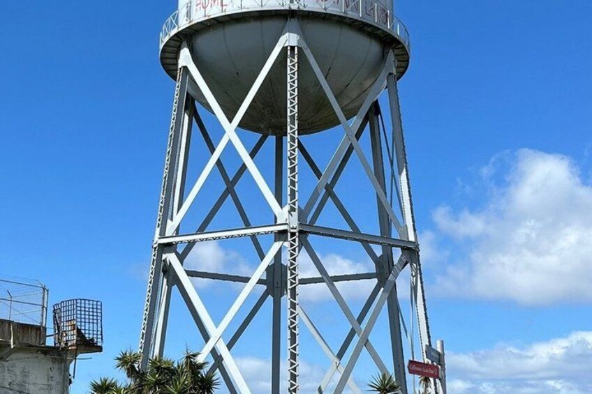 A tall water tower with a metal lattice structure and a spherical tank on top. 4