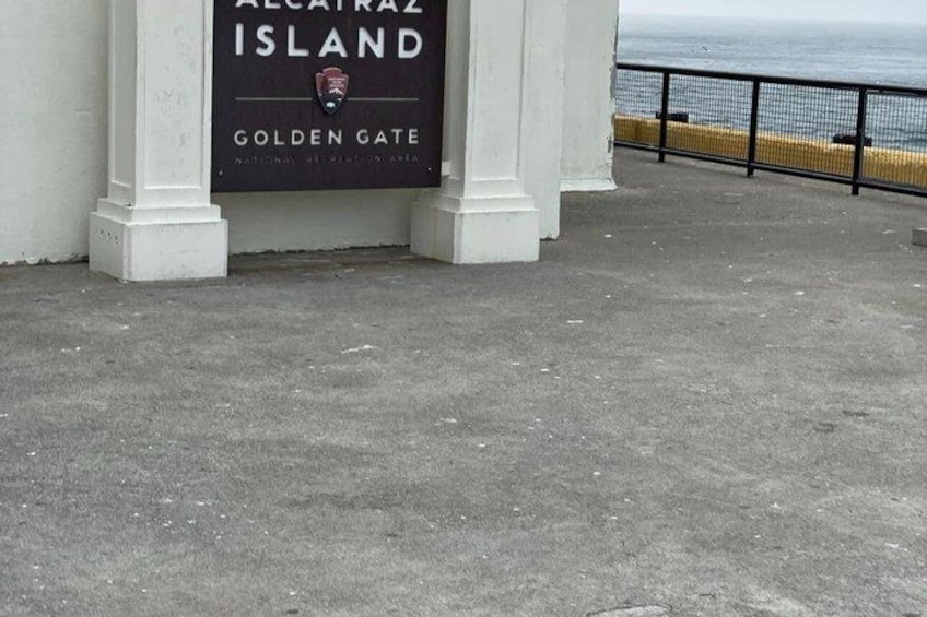 A concrete walkway with a sign for Alcatraz Island's Golden Gate. 2
