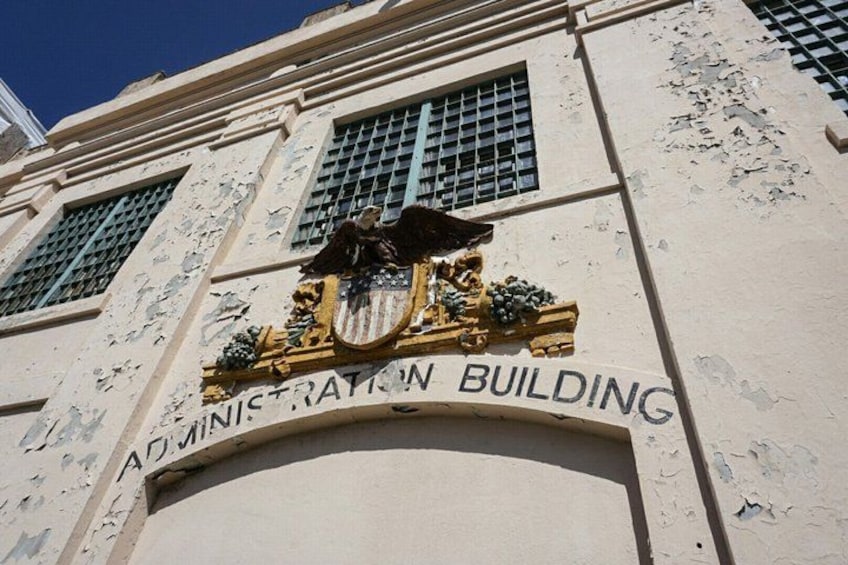 A building with a sign that reads 'Administration Building' and a coat of arms above the entrance. 3