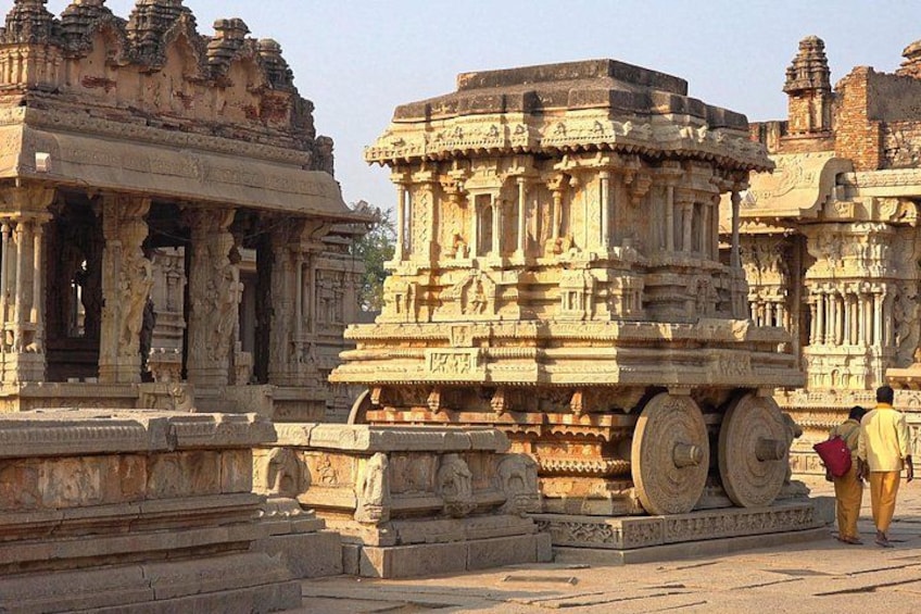 An ancient temple with intricate carvings and large wheels. 1