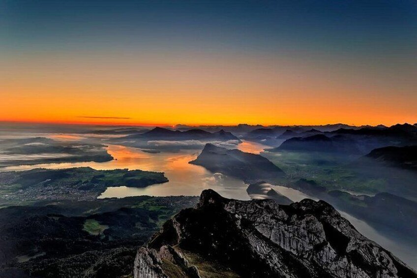 Een bergachtig landschap met een zonsondergang, weerspiegeld in het water. 2