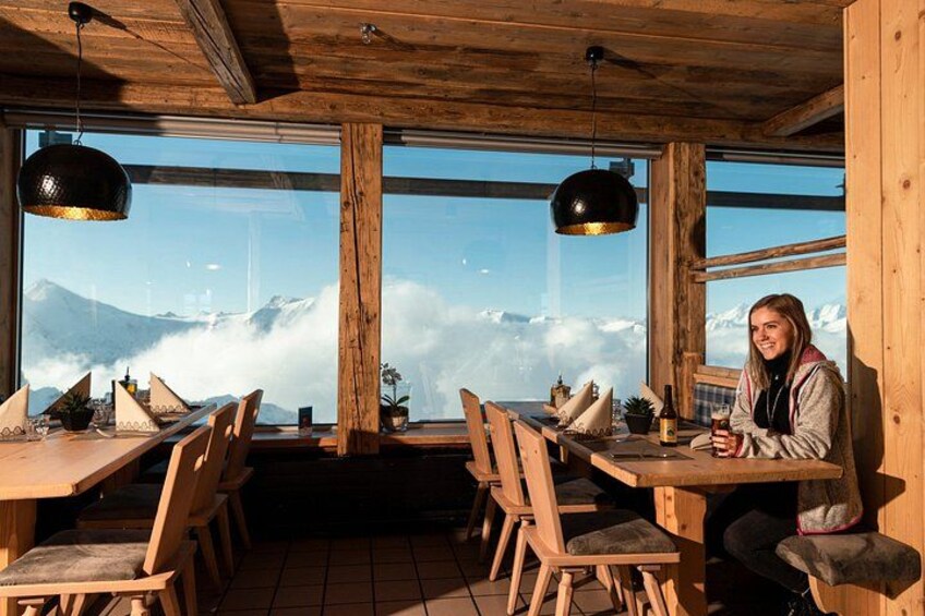 Un interior de madera con ventanas amplias que dan a una montaña nevada. 3