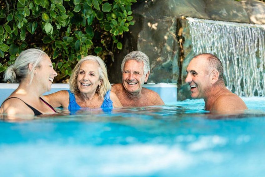 A swimming pool with a waterfall feature in the background. 3
