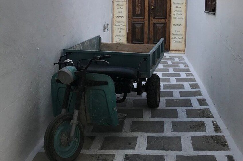 Un callejón estrecho con un carrito verde estacionado junto a una pared. 4